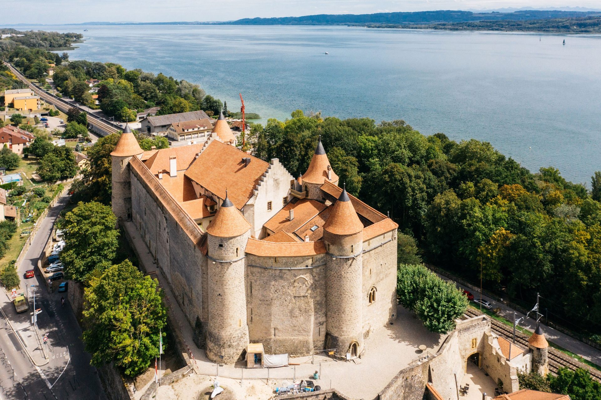 Vogelperspektive auf die Dächer von Schloss Grandson, im Hintergrund der Neuenburgersee.